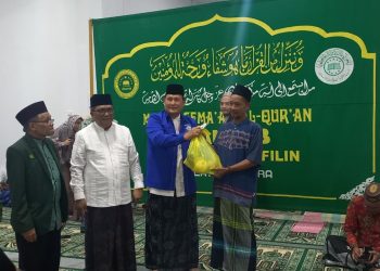 Pendeta Marlon Kojongian diminta untuk menyerahkan sembako kepada salahsatu kaum dhuafa Didampingi Ketua PWNU Sulut Dr Ulyas Taha dan sekretaris Masri Soleman 