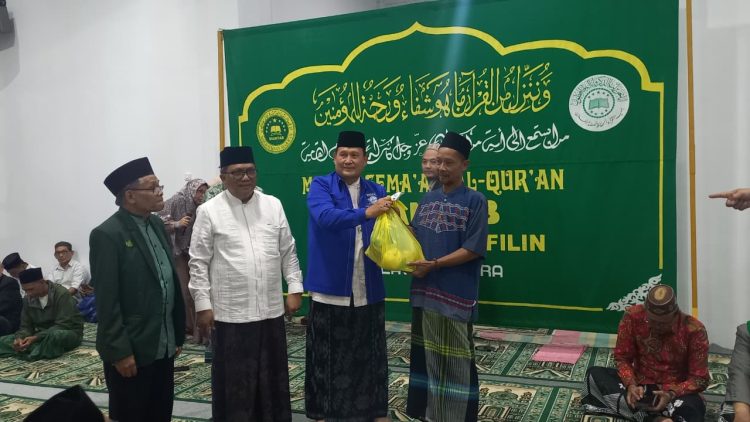Pendeta Marlon Kojongian diminta untuk menyerahkan sembako kepada salahsatu kaum dhuafa Didampingi Ketua PWNU Sulut Dr Ulyas Taha dan sekretaris Masri Soleman 